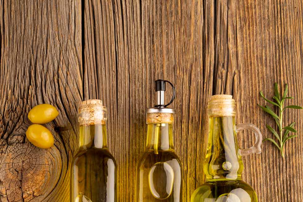 Botes de aceite de oliva sobre mesa de madera